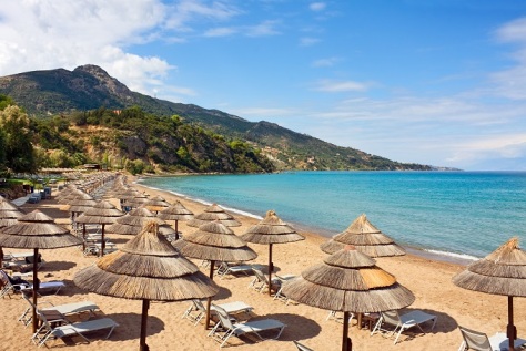 1row_of_straw_umbrellas_and_lounges_at_sandy_beach_of_zakynthos_greece._shutterstock_142721089